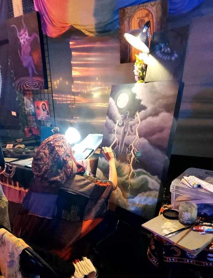The artist at work in their studio, painting by lamplight